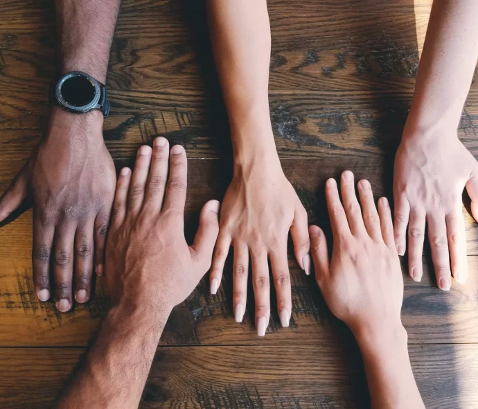 photo de mains d'hommes et de femmes montrant la diversité dans le monde professionnel